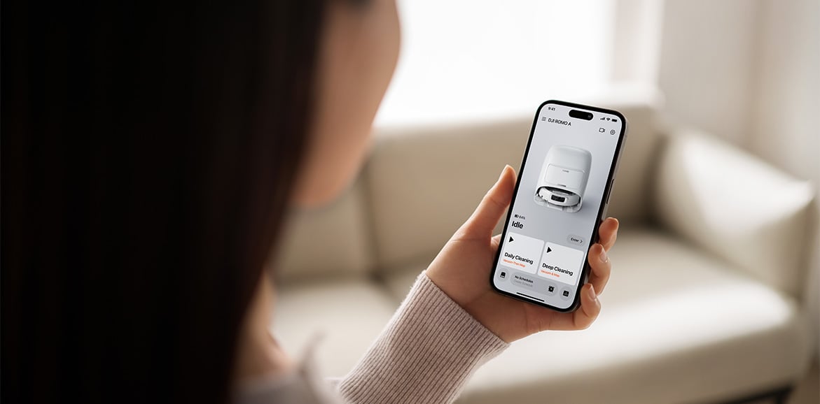 Kobieta używa aplikacji DJI HOME do kontroli robota sprzątającego DJI ROMO A